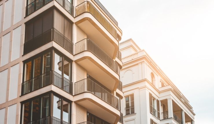 Modern apartment building with balconies next to a residential complex